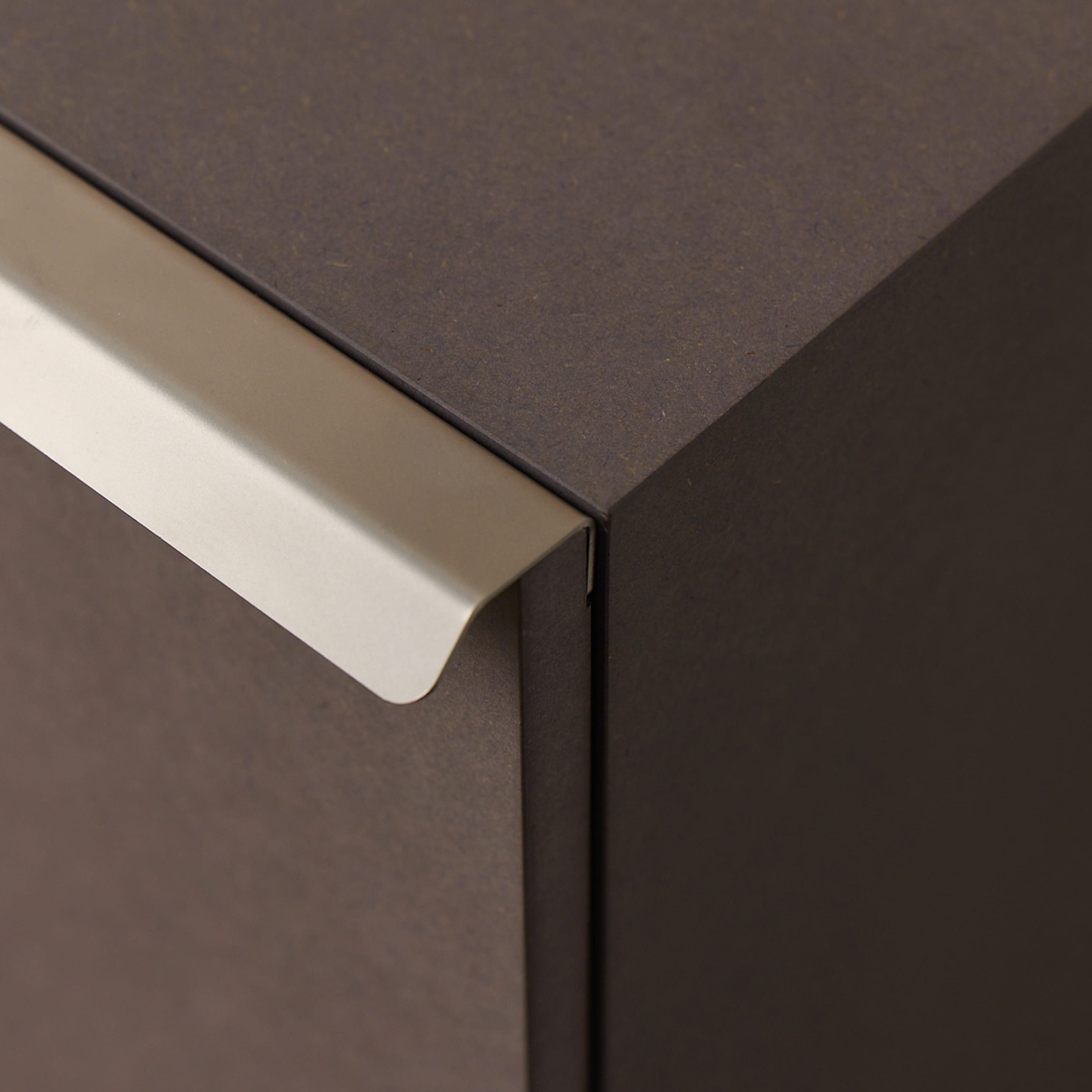 Ecke eines Korpus in Holzfaserwerkstoff, hochverdichtet und durchgefärbt, mit Edelstahl-Griff