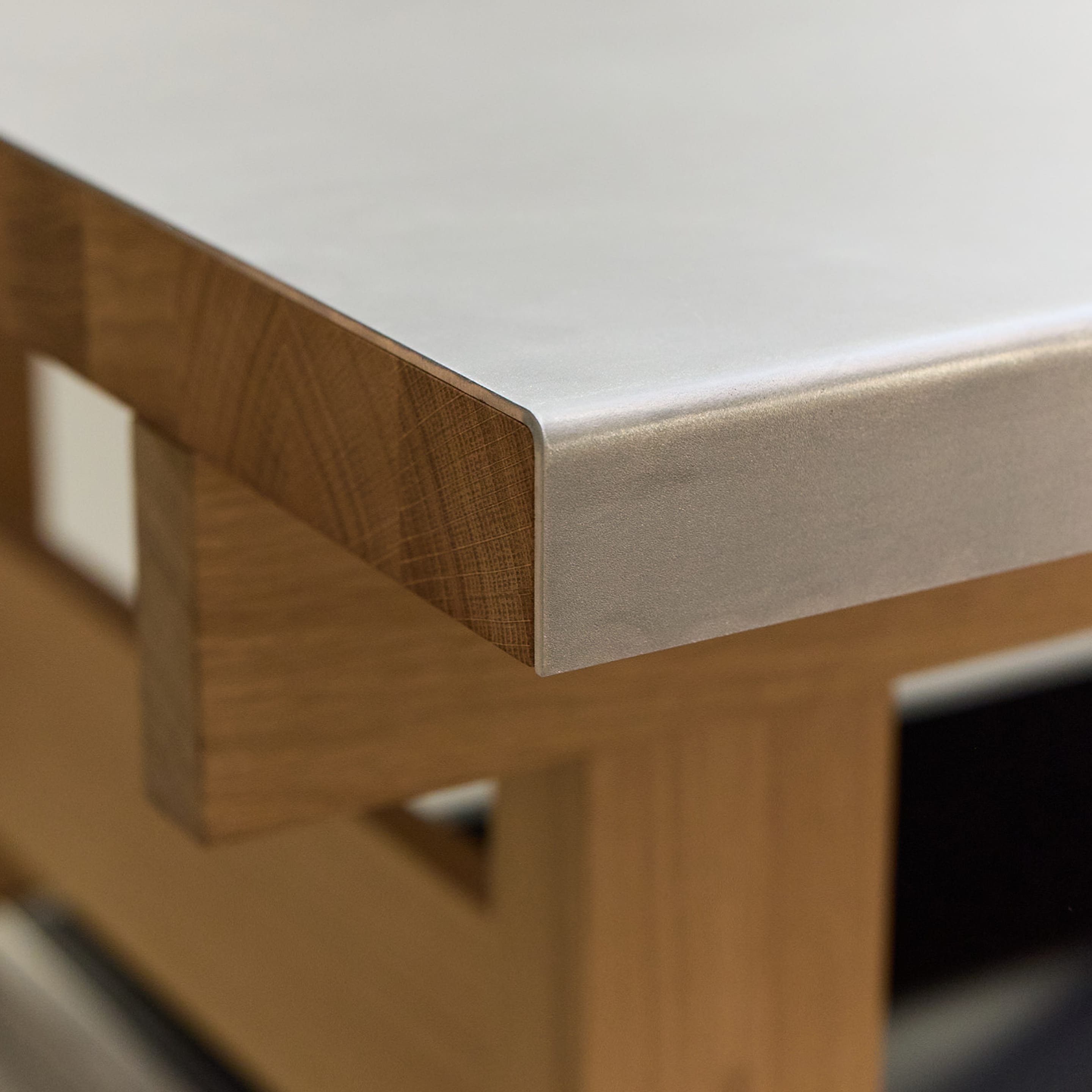 Detailansicht: Gefalzte Edelstahl-Oberfläche auf Massivholz Eiche, Kantenansicht